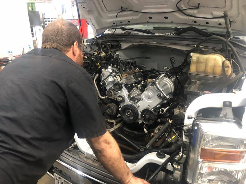 Speeler Automotive mechanic inspecting a truck engine
